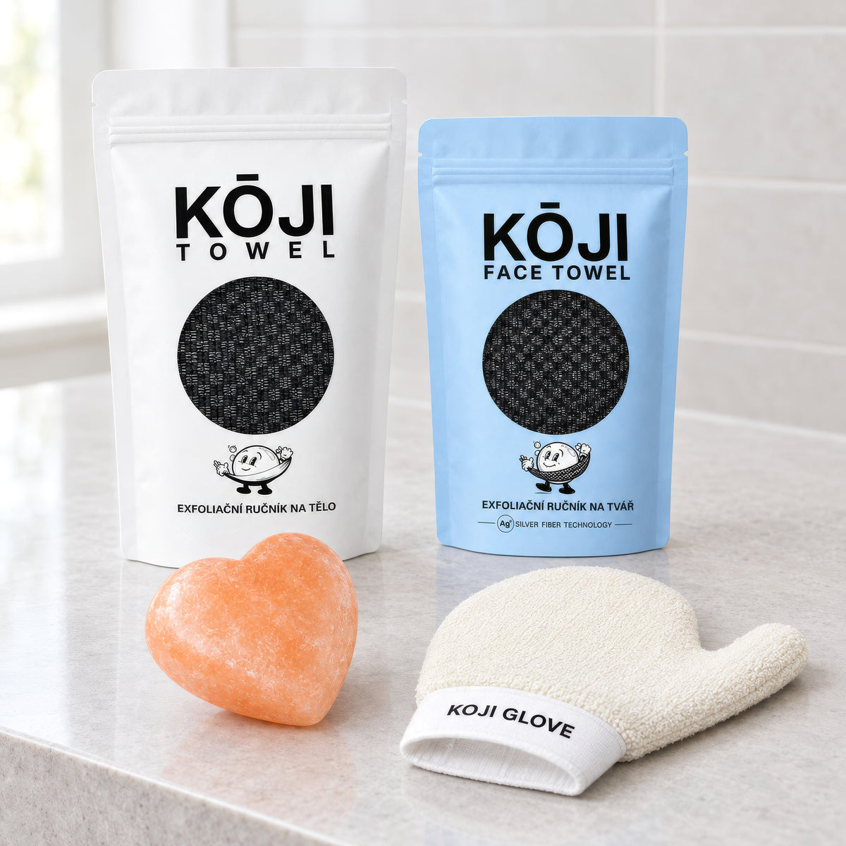 Čtyři produkty sady Kōji vedle sebe na kamenné koupelnové desce.